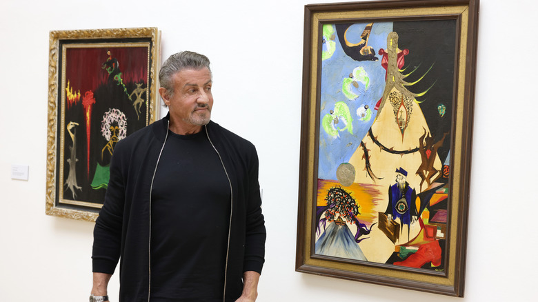 Sylvester Stallone standing with art