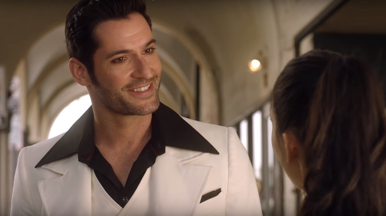 Tom Ellis wears a white suit