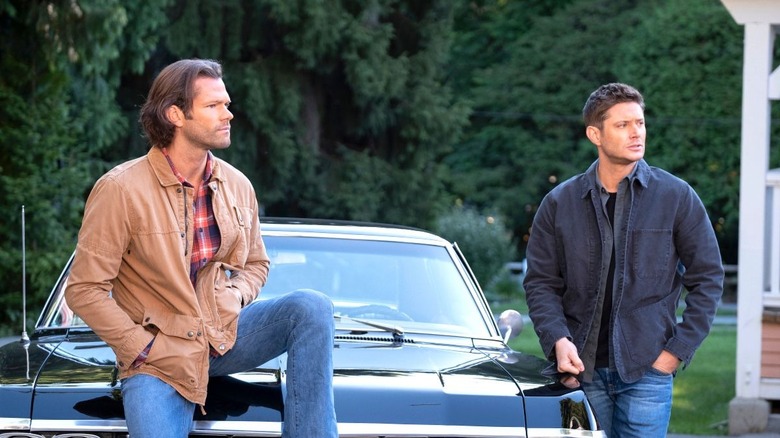 Dean and Sam lounging on Impala