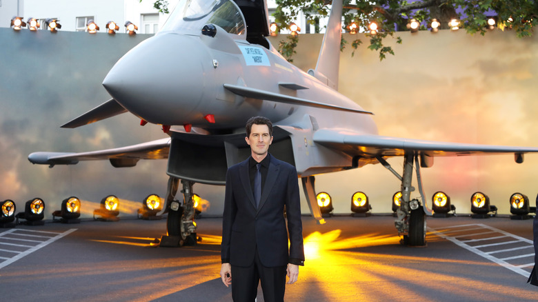 Joseph Kosinski standing near fighter jet