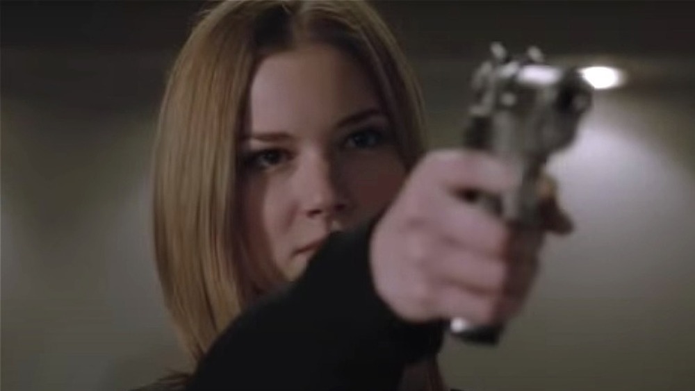 Emily VanCamp as Emily Thorne pointing a gun in a scene from Revenge 