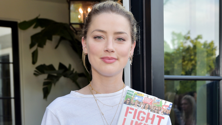 Amber Heard holding a book