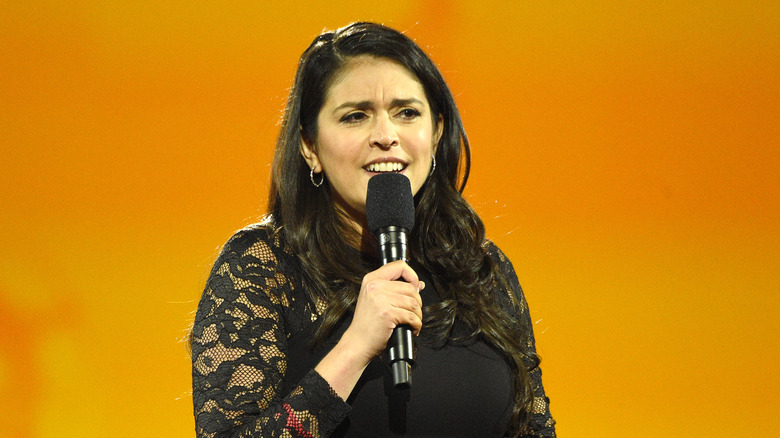 Cecily Strong on stage holding mic