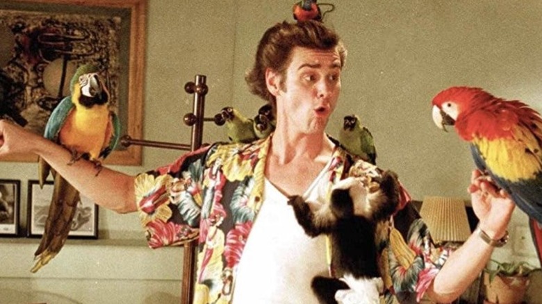 Jim Carrey stands with several exotic birds