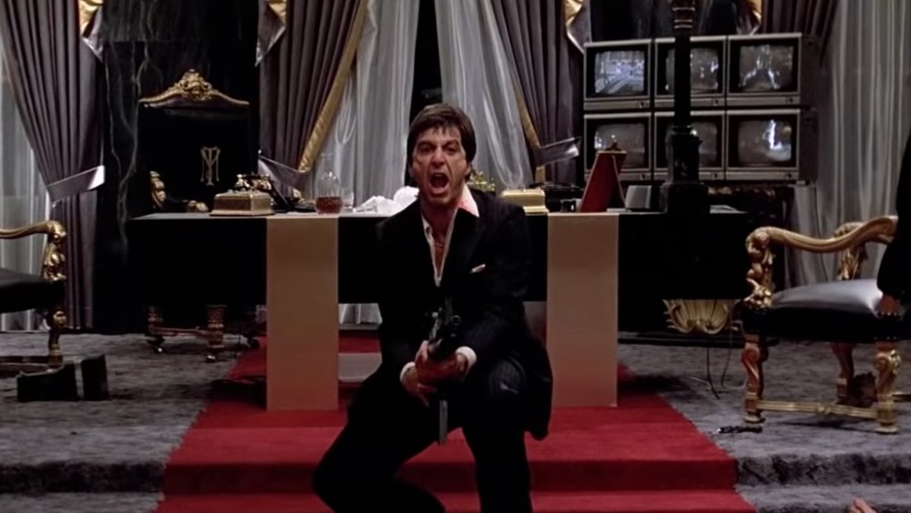 Al Pacino as Tony Montana, branding a gun in Scarface