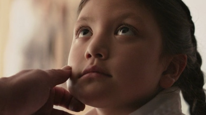 Young Maya Lopez gazing up at her father