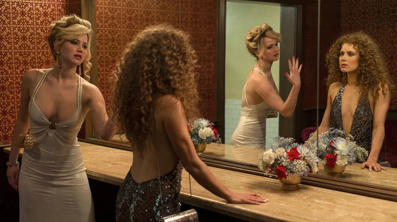 Jennifer Lawrence showing nails to Amy Adams in bathroom