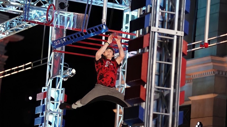 Kaden Lebsack hanging on monkey bar obstacle