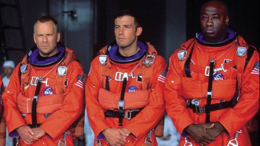 Harry, A.J., and Bear stand in a line wearing spacesuits