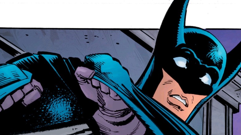 Batman looks alarmed while he clutches his cape