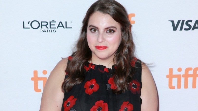 Beanie Feldstein smiling on red carpet