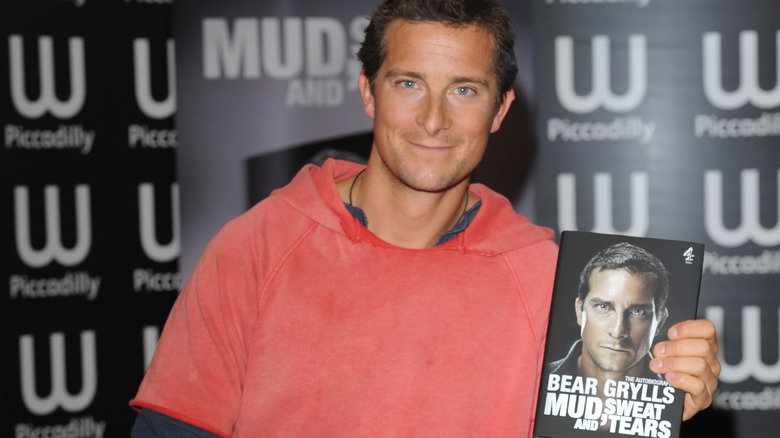 Bear Grylls holding his book