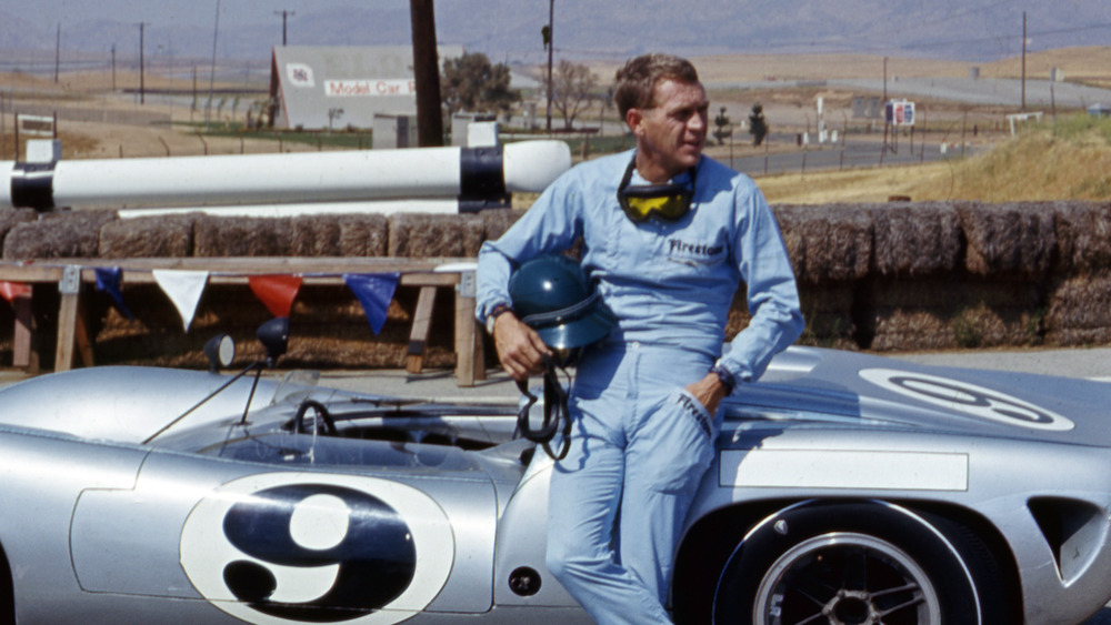 Steve McQueen leaning on racecar