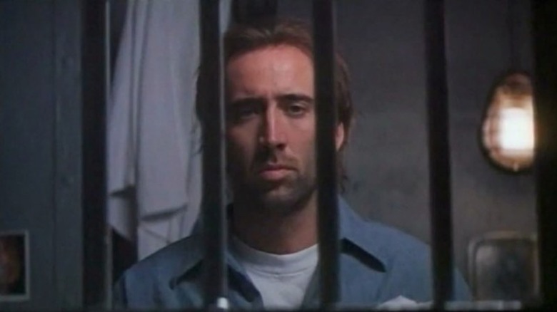 Cage standing behind bars