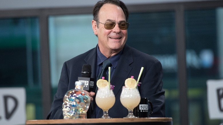 Dan Aykroyd sits at a table with a display of Crystal Head vodka