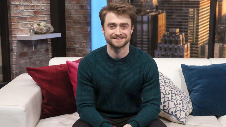 Daniel Radcliffe smiling on couch