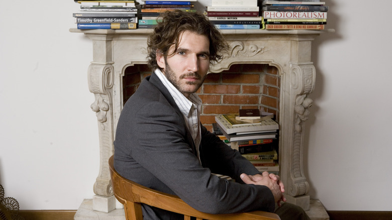 David Benioff sits in front of fireplace