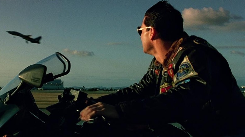 Maverick watching a plane from his motorcycle