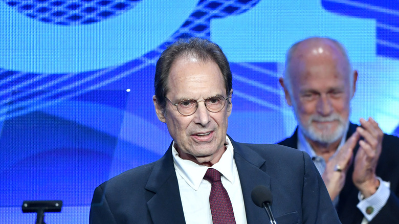 David Milch smiling while Gerald McRaney applauds