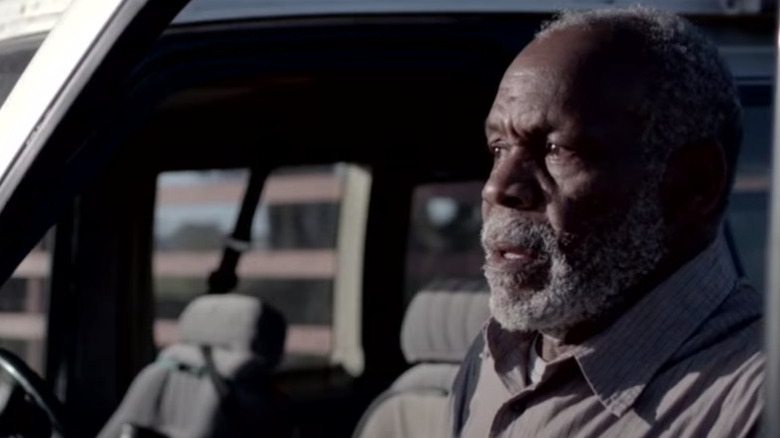 Danny Glover stands by car