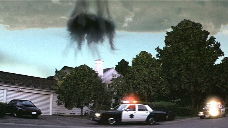 Police car under black dust cloud