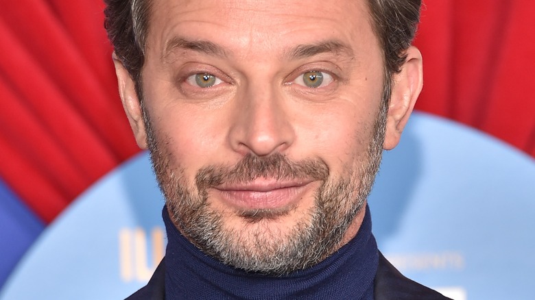 Nick Kroll smiling in a turtleneck