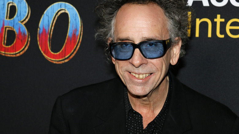 Tim Burton in sunglasses smiling at the Dumbo premiere