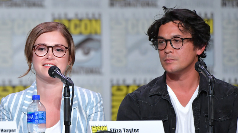 Eliza and Bob sit in front of microphones