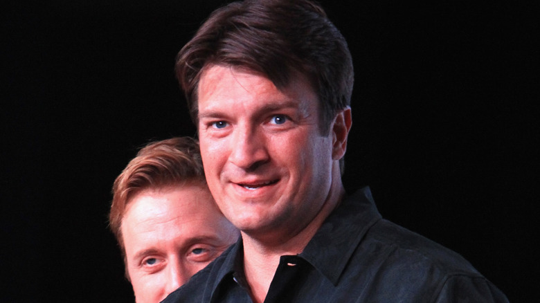 Nathan Fillion smiling with Alan Tudyk