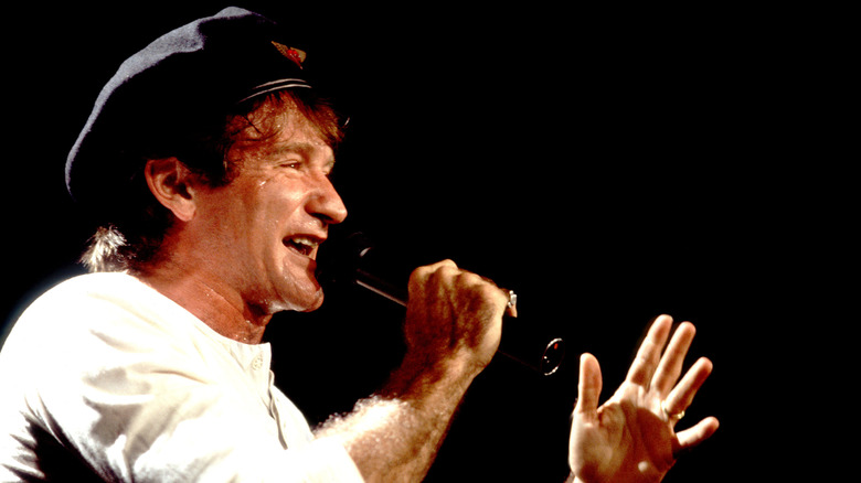 Robin Williams performing holding mic