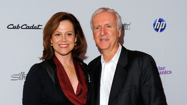 Sigourney Weaver and James Cameron smile for picture on red carpet