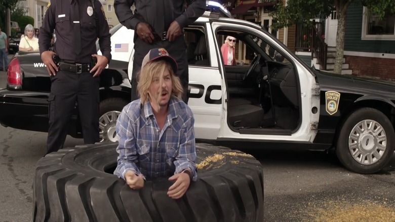 David Spade climbing out of a tire