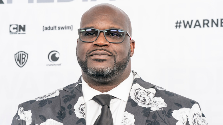 Shaquille O'Neal wearing a suit and glasses