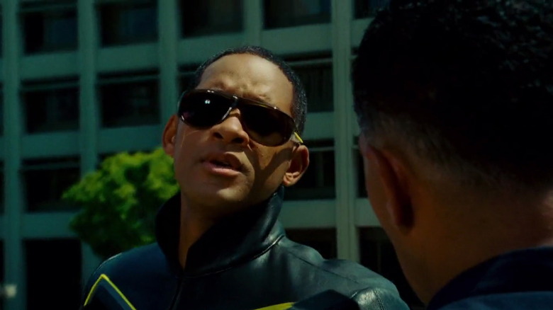 Hancock in shades talking to a police officer