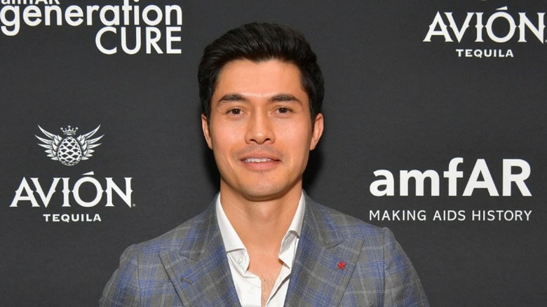 Henry Golding smirking 