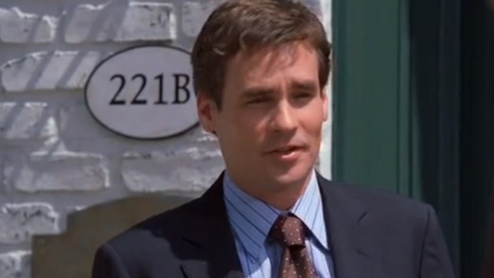 Wilson stands in front of 221B sign