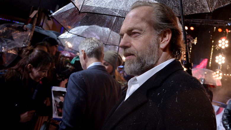 Hugo Weaving walking in the rain