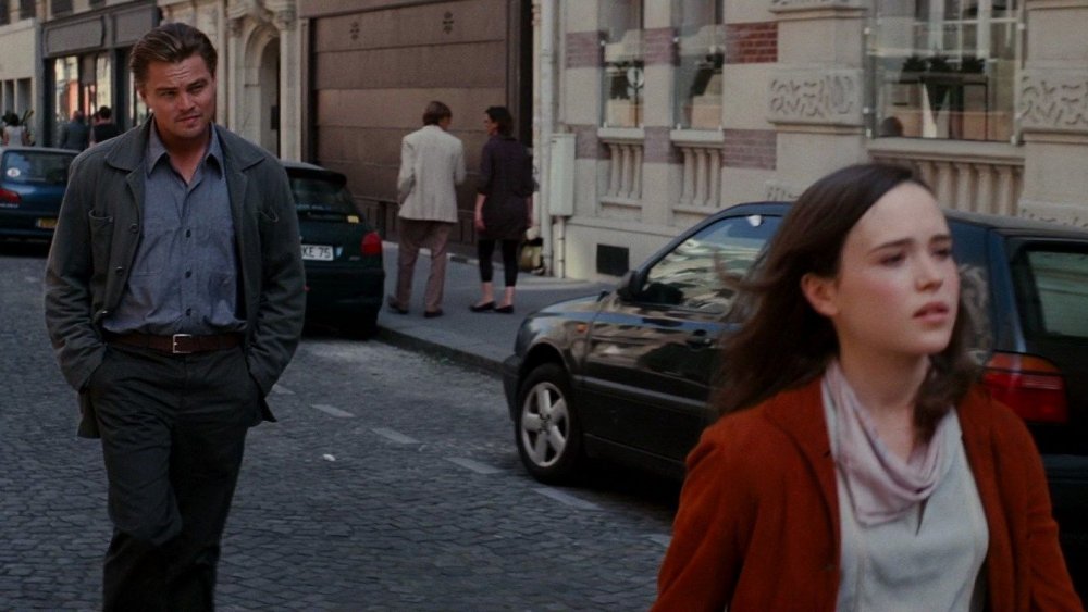 Leonardo DiCaprio as Cobb follows close behind Elliot Page as Ariadne on a Paris street in Inception