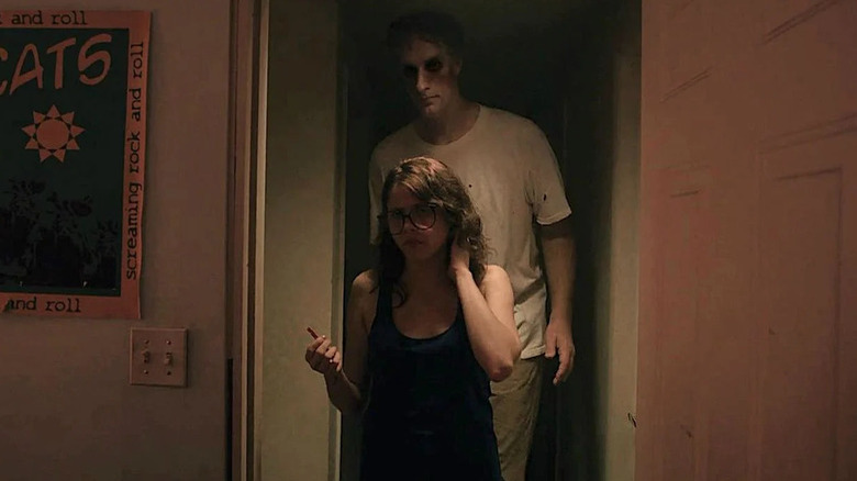 Tall man standing behind girl in glasses