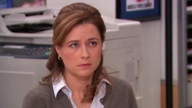 Pam frowns behind desk