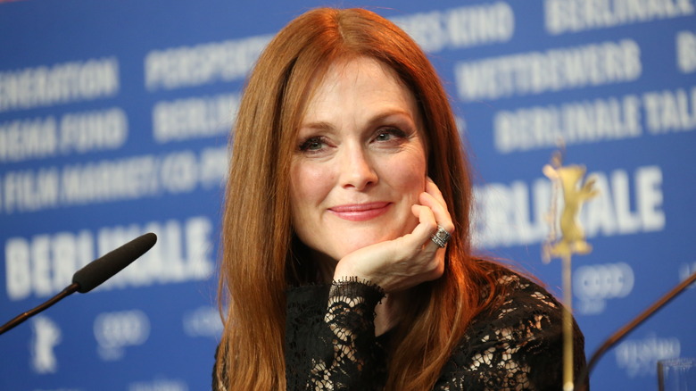 Julianne Moore rests head on hand at table