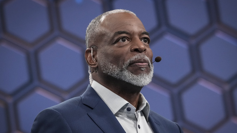 LeVar Burton looking up with a microphone