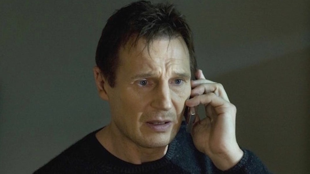 Liam Neeson talking on the phone in a scene from Taken