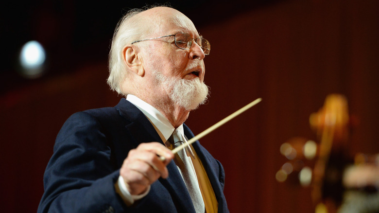 Composer John Williams conducting with baton