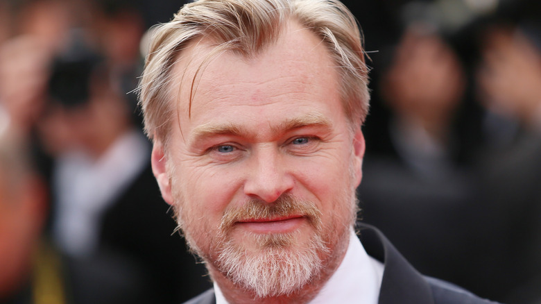 Christopher Nolan smiles in a tuxedo