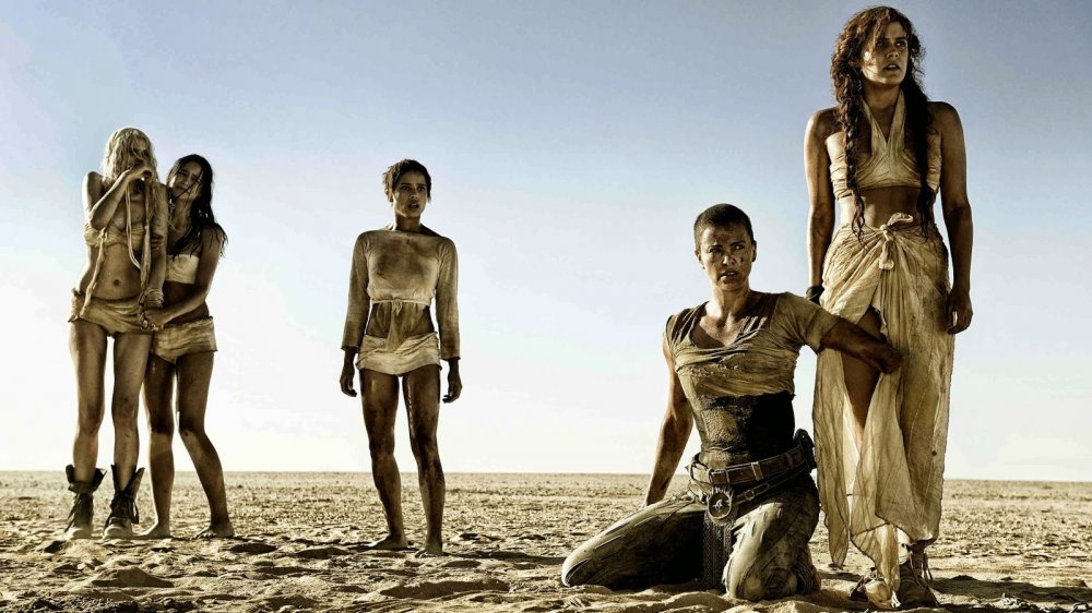 Charlize Theron as Furiosa, protecting Immortan Joe's wives in Mad Max: Fury Road