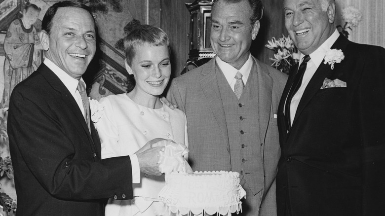 Mia Farrow and Frank Sinatra cutting wedding cake