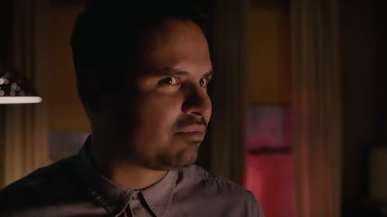 Michael Pena looks off to side in dark living room