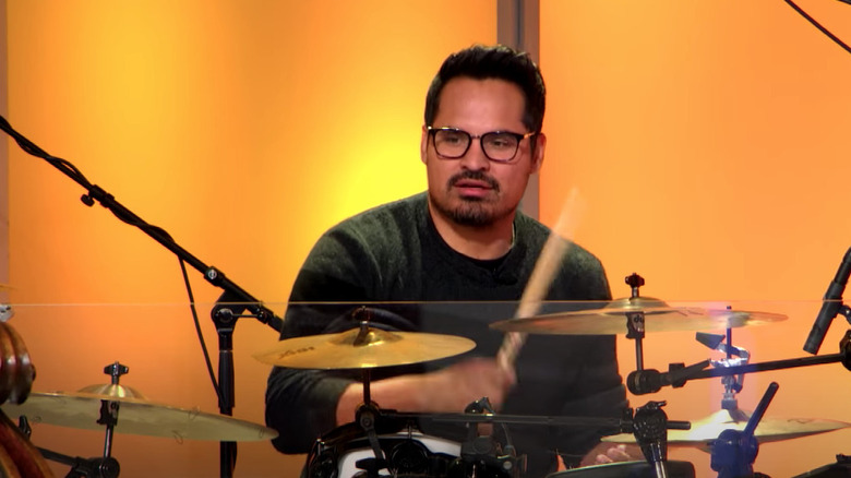 Michael Pena drums in front of orange background