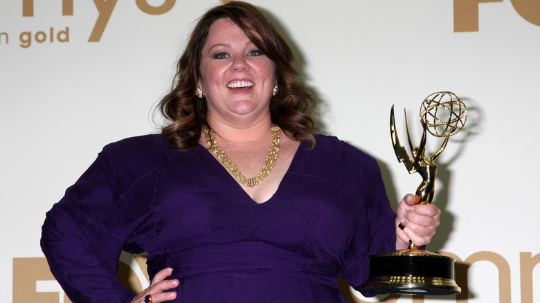 Melissa McCarthy holding her Emmy